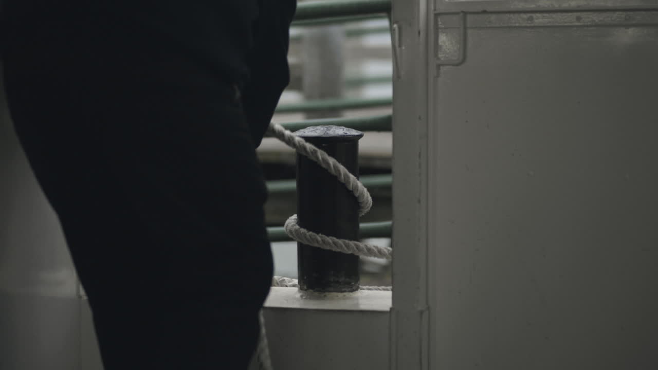 Ship worker pulling the cruiser ship closer to the boardwalk secure the ship so that the passengers can safely exitthe cruising ship