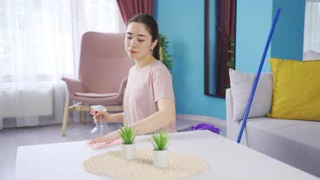 pensive asian young woman cleaning at home.