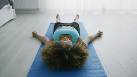 mujer acostada en la alfombra relajándose y respirando