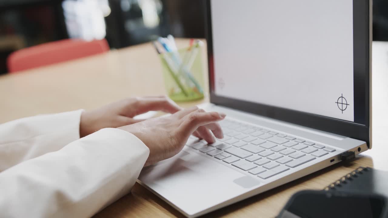 Close up of hands of biracial businesswoman using laptop with copy space on screen, in slow motion