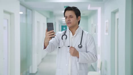 serious indian doctor talking on video call