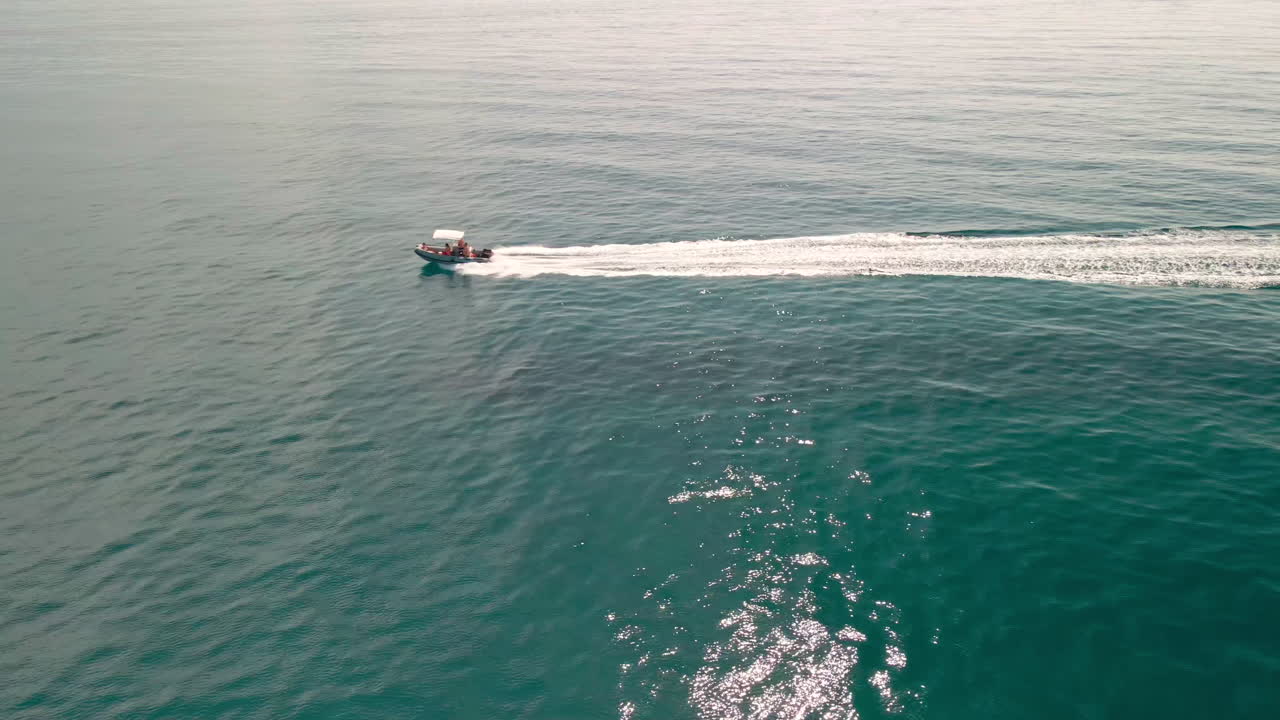 바다에서 고속으로 움직이는 보트, 여름 동안 이탈리아 사르데냐에서 긴 웨이크가 보트를 따라갑니다 - 공중 정적 샷