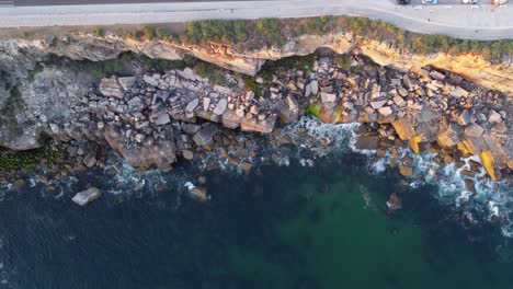 aerial top down panning shot of a rocky coastline in cascais, portugal