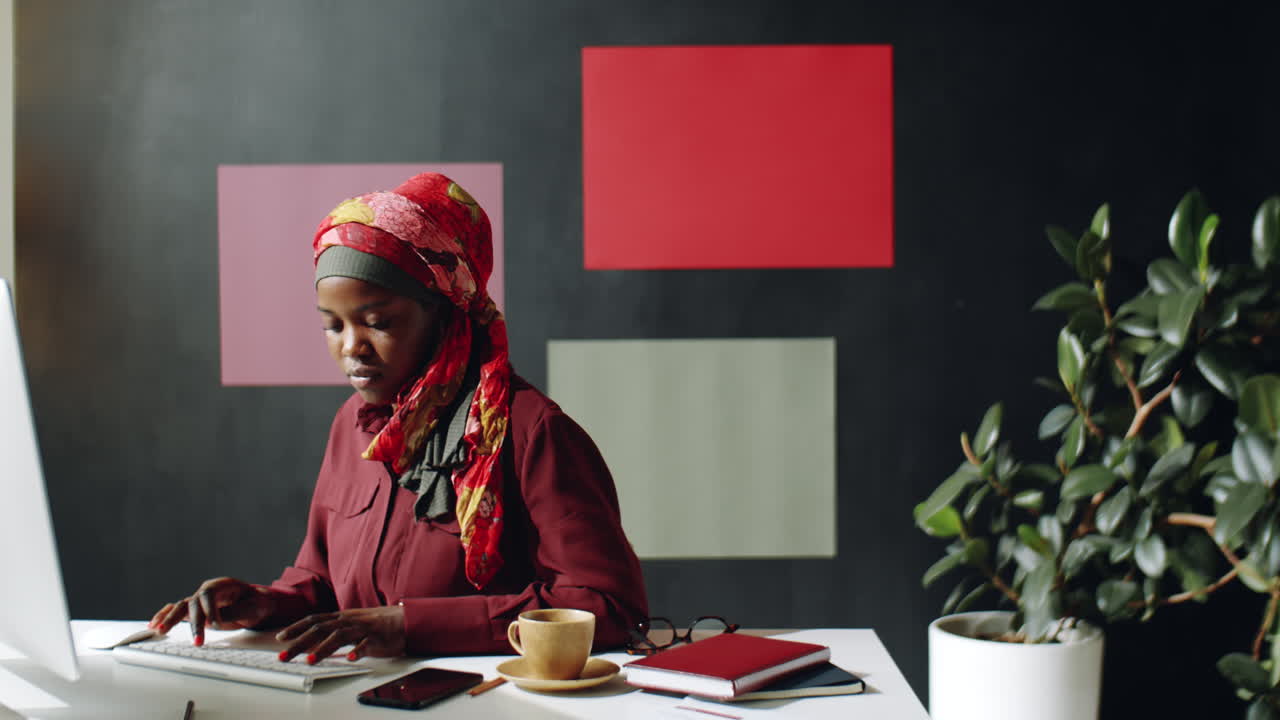 흑인 여성이 컴퓨터에서 타이핑하고 있습니다.