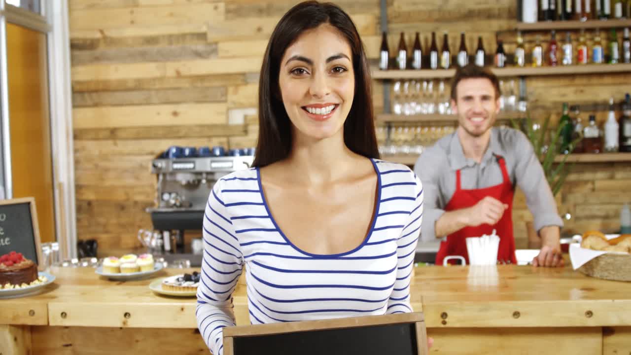 mujer de pie con un cartel abierto en el café 4k