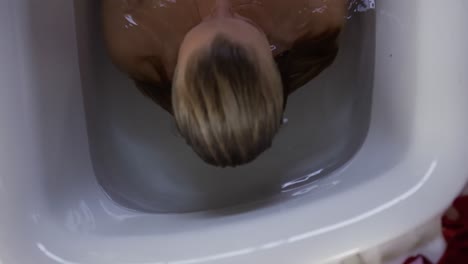 mujer caucásica tomando un baño en el hotel