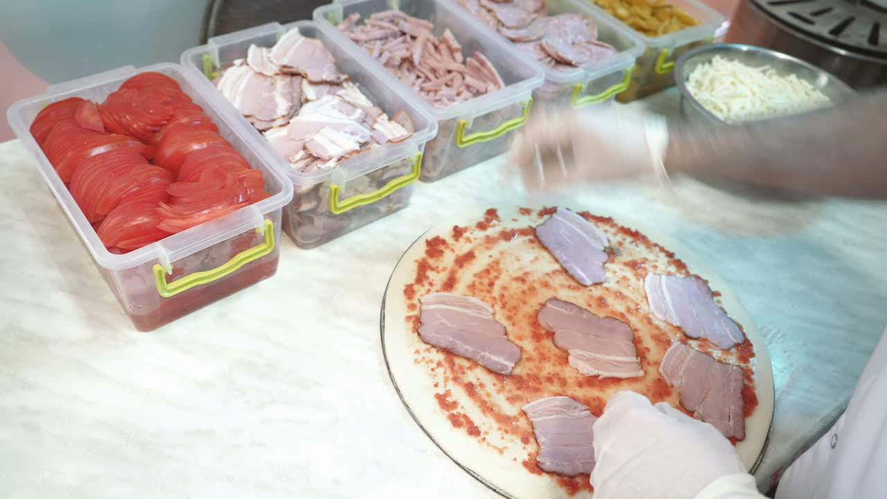 Skillful chef preparing a pizza. Hands of man in action
