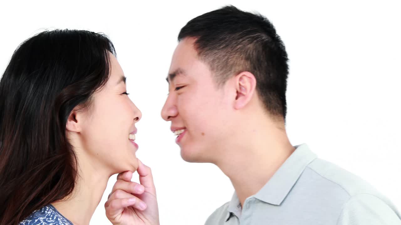 행복 한 커플 이 키스 하고 미소 짓고 있다