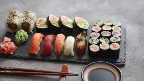 composición de diferentes tipos de rollos de sushi colocados en tablero de piedra negra