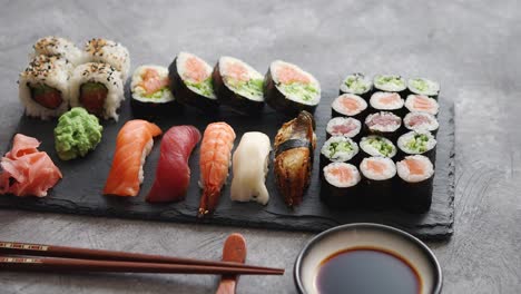 composition of different kinds of sushi rolls placed on black stone board