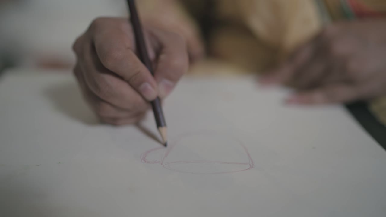 Footage of sketching on white paper using pencil.
