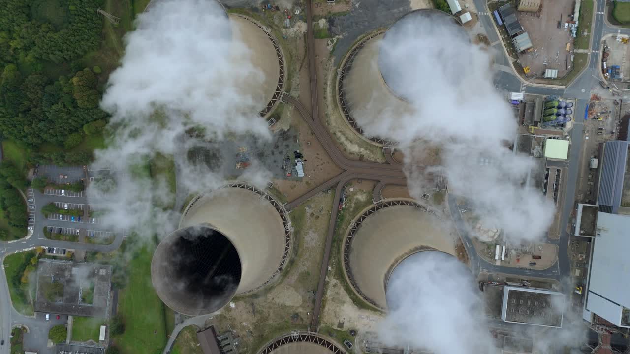Overhead drone orbit of electricity generation site, chimney stacks and cooling towers on Humber Estuary fringe UK