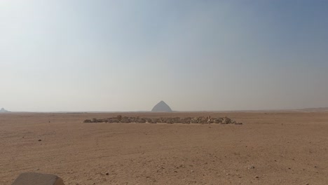 Establishing-shot-of-Egyptian-desert-with-Bent-Pyramid-in-horizon,-Dahshur