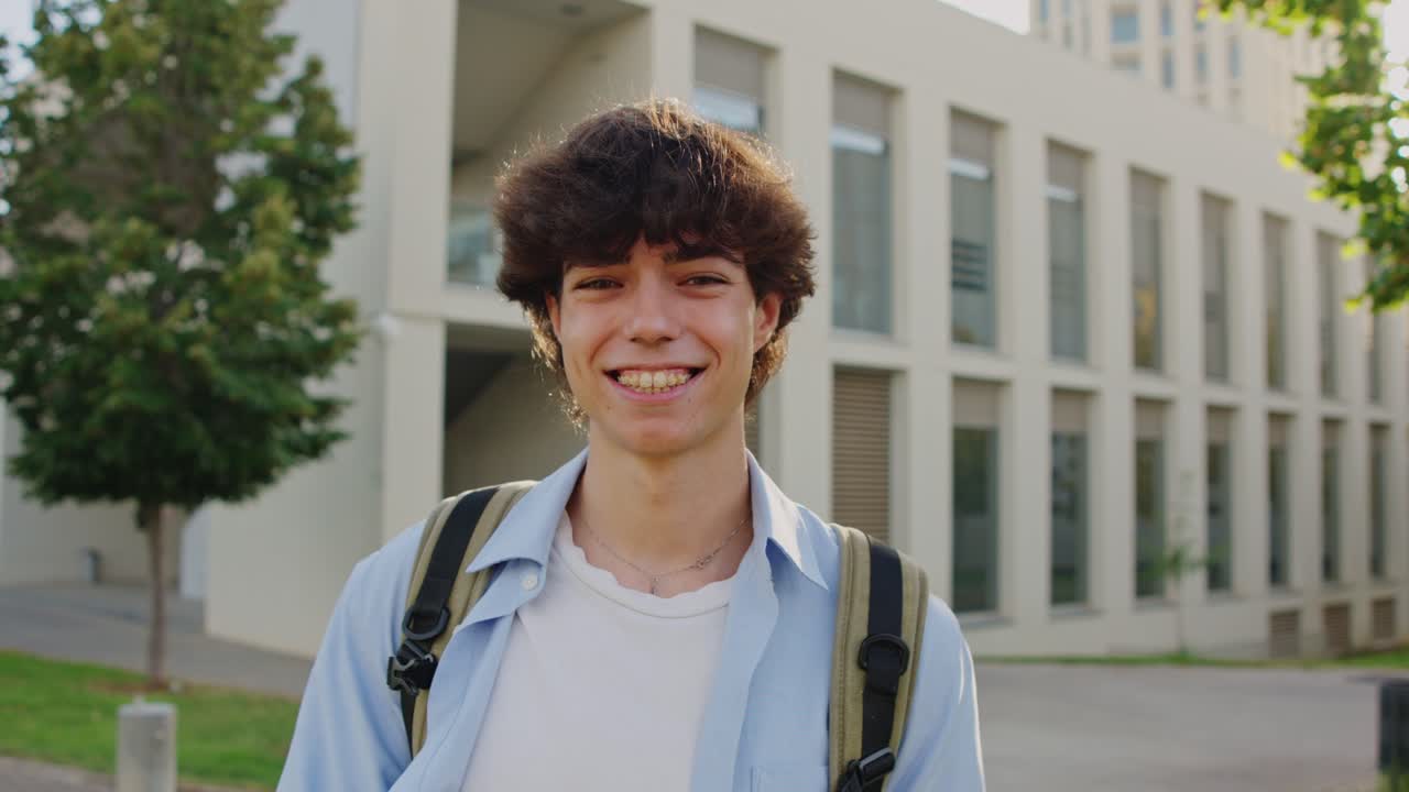 Portrait of a smiling student with a backpack on campus