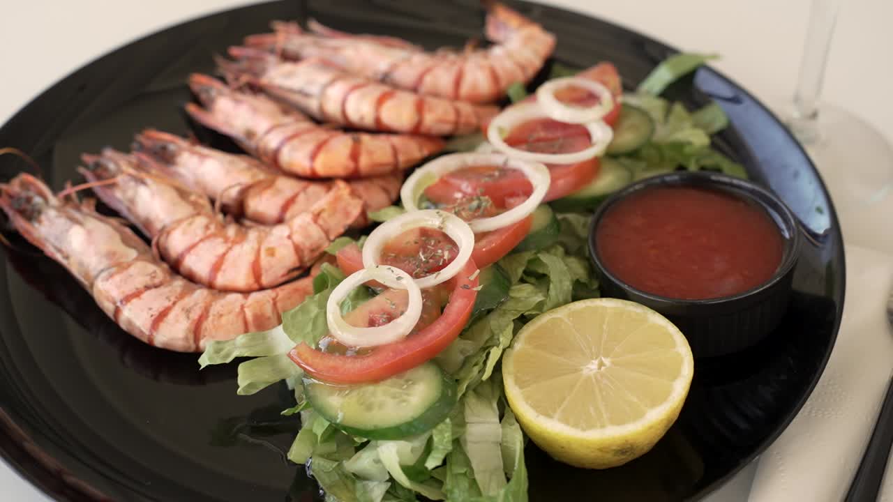 Delicious seafood feast featuring fresh grilled shrimp and vibrant salad on a black plate