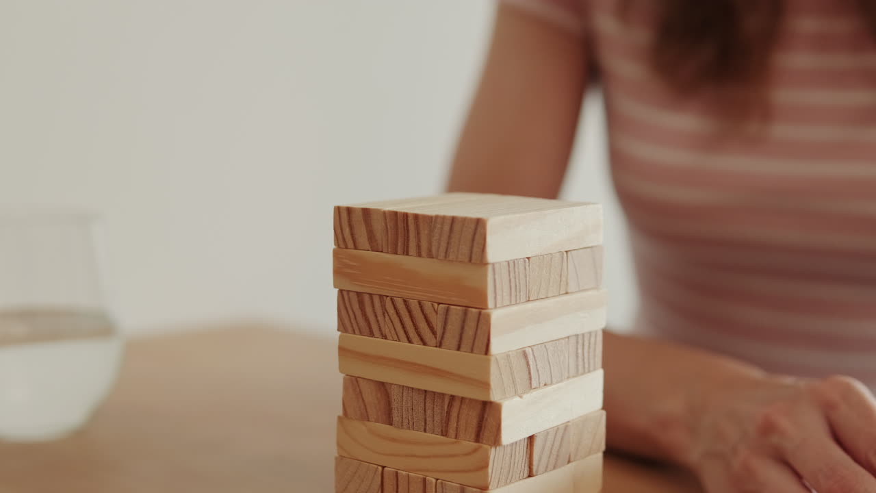 Woman Plays Wooden Block Game at Home