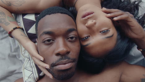 above view of young couple lying head to head on bed