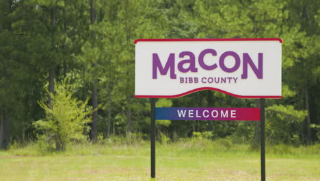 Macon-Bibb-County-Georgia-welcome-road-sign-in-front-of-woods-telephoto-pan-left-60p-0002