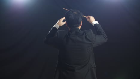 흑인 스튜디오에서 지이를 들고 몸짓을 하는 아시아인 지휘자