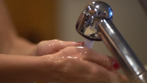 female wash hands with water and soap