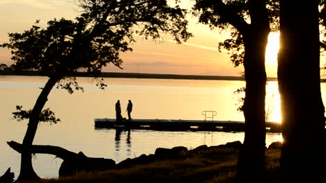 Drei-Junge-Frauen-Beobachten-Den-Sonnenuntergang-Vom-Dock-Am-Far-West-Reservoir-In-Der-Nähe-Von-Spenceville-Wildlife-Area-Yuba-City-Kalifornien