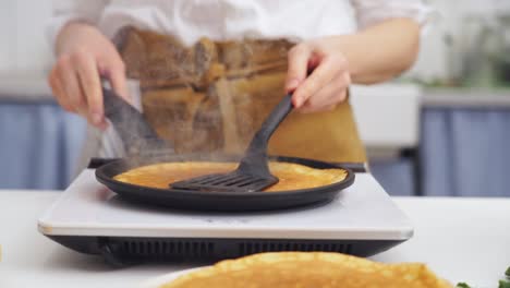 cook flipping a pancake in the frying pan