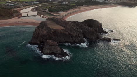 Aerial-drone-fly-above-calm-waves,-rock-islet-at-Japanese-beach-landscape-Kyoto