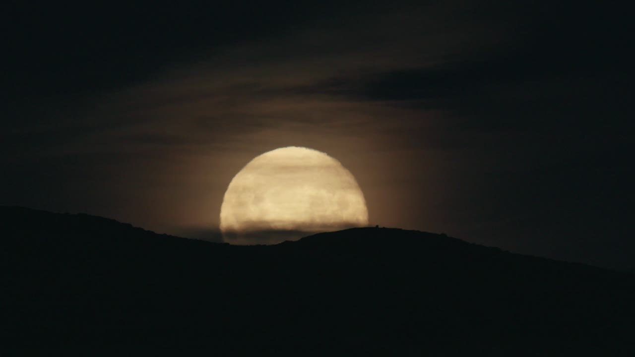 Moonrise over horizon on a cloudy night