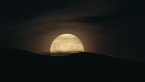 salida de la luna sobre el horizonte en una noche nublada