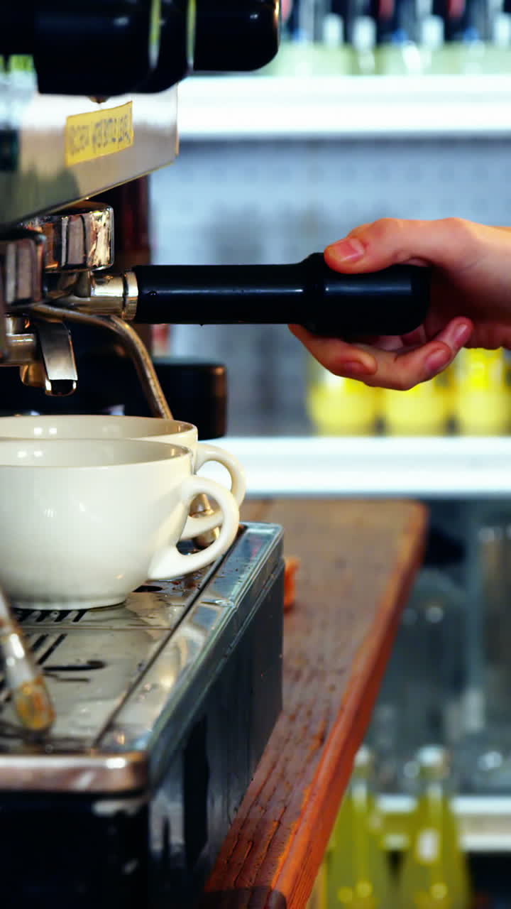 camarera haciendo una taza de café en el mostrador en la cocina