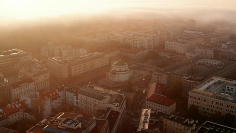 Slide-and-pan-footage-of-town-development.-Round-sacral-building-in-town-square.-Misty-weather-at-sunrise.-Warsaw,-Poland