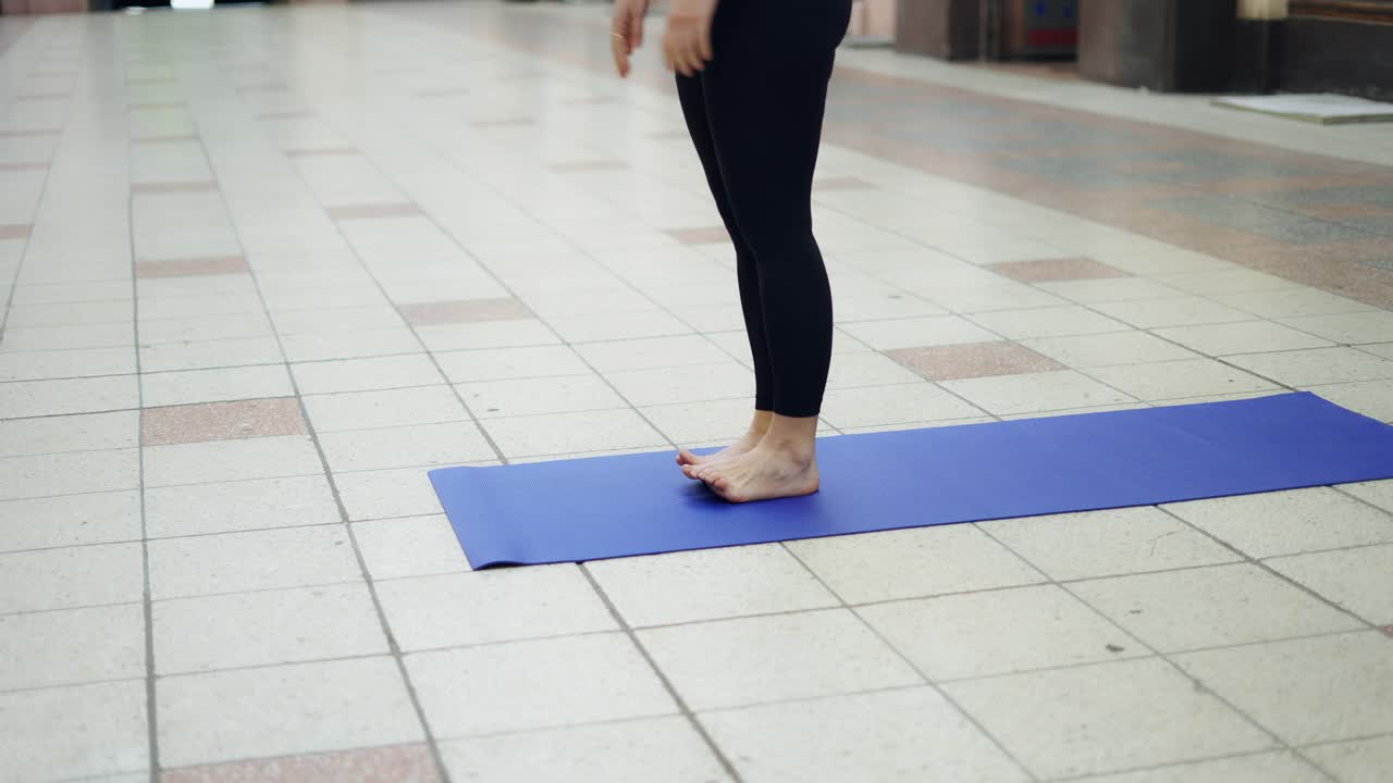 cerca de una mujer descalza de pie en el tapete, irreconocible