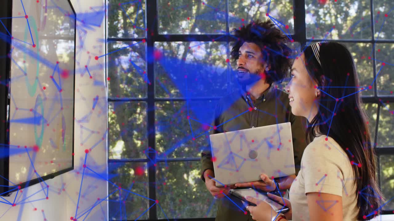 Lead pointing laptop, starting tech review; woman using tablet, network overlay covering team