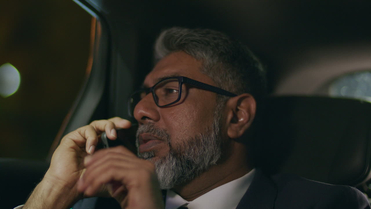 Dirigente senior che parla di affari al telefono mentre è in auto di notte
