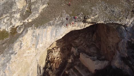 rock climbers hanging from a tall cliff drone shot