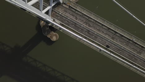 Aerial-footage-looking-down-onto-the-old-Forth-Road-Bridge-on-a-sunny-day-at-South-Queensferry-in-West-Lothian,-Scotland