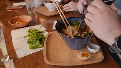 varón caucásico preparándose para comer un plato de fideos ramen