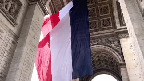 Cámara-Lenta-De-La-Bandera-Francesa-Ondeando-En-El-Viento-En-El-Arco-Del-Triunfo-En-París,-Francia