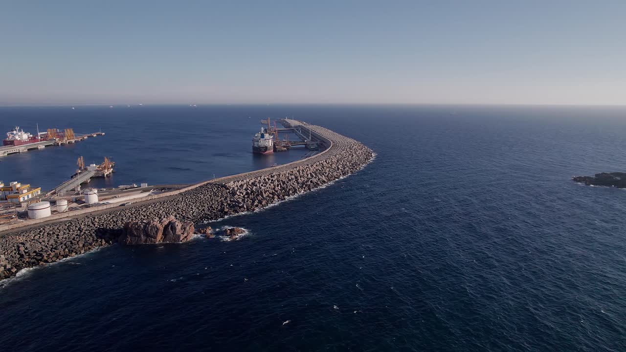 Frangiflutti curvo del porto di Sines al Miradouro da Costa Norte, Parco Naturale della Costa Vicentina, Sines, Distretto di Setúbal, Alentejo, Portogallo — lento avvicinamento aereo con drone