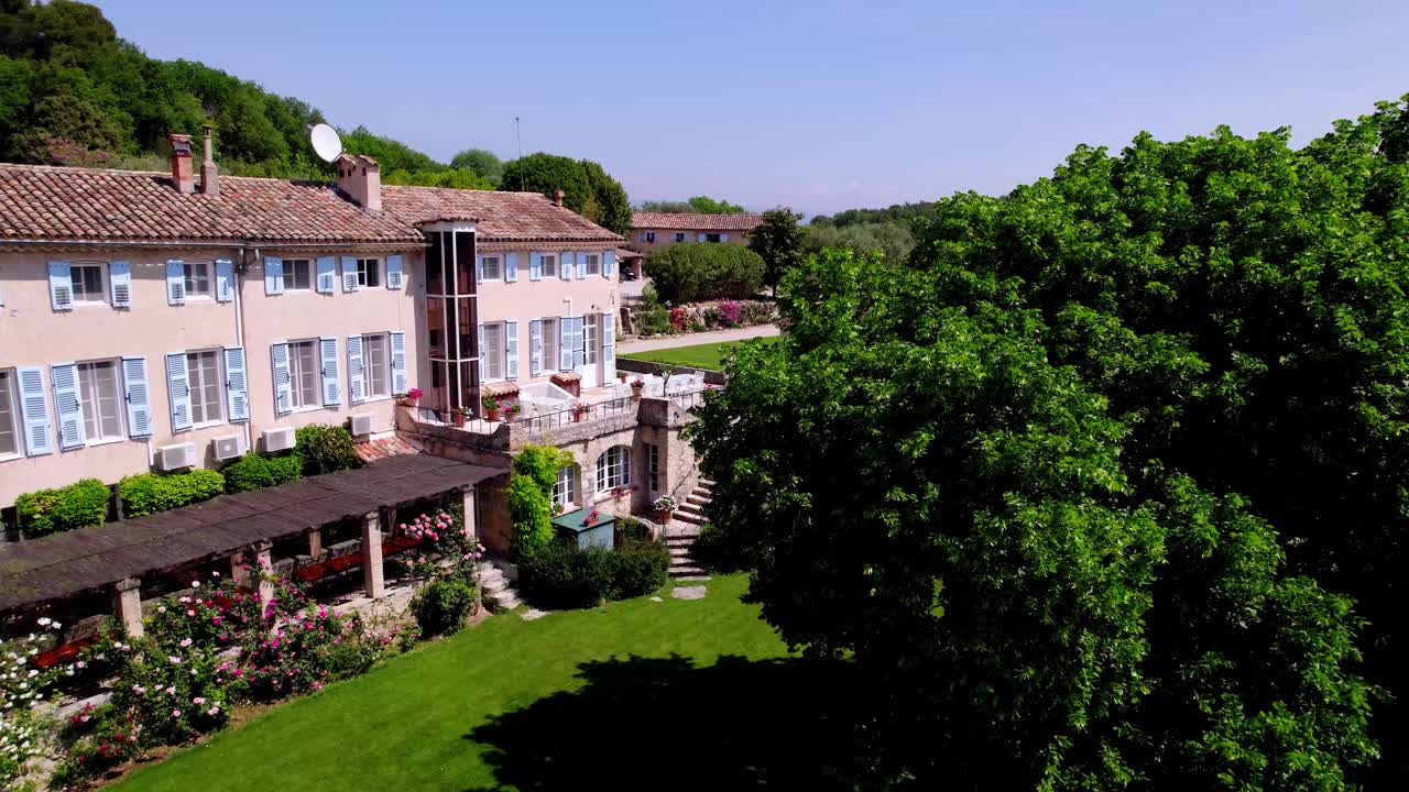 드론이 프로방스 마스 (provençal mas) 로 여행하는 모습: 파란색 셔터, 초록색 잔디, 장미 정원, 꽃병을 드러내는 모습