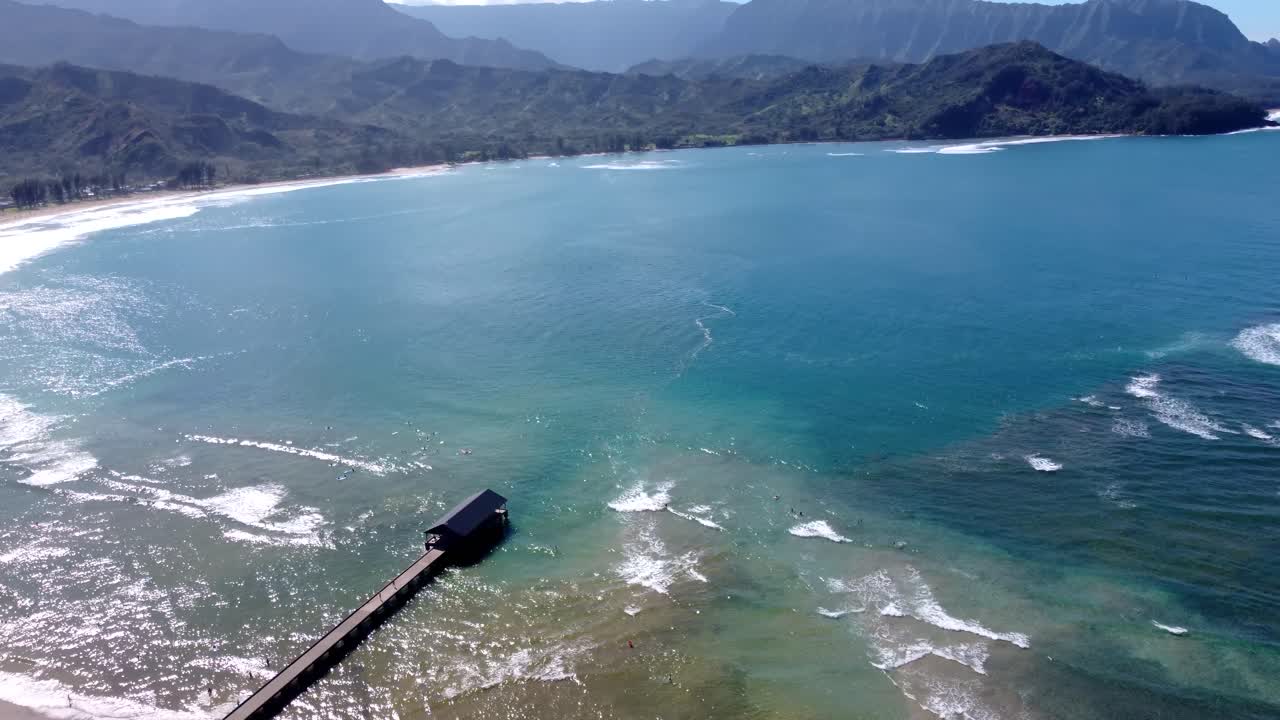 Beautiful Hanalei pier on a sunny day in kauai, Hawaii. Hanalei bay beach pier known for its picturesque views of the mountains ocean. Kauai north shore Hawaii island aerial footage of Hanalei Pier