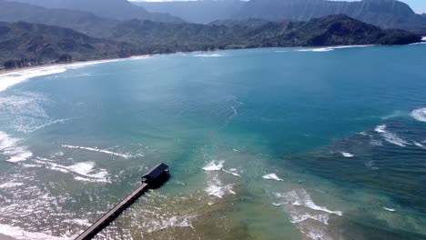 beautiful hanalei pier on a sunny day in kauai, hawaii. hanalei bay beach pier known for its picturesque views of the mountains ocean. kauai north shore hawaii island aerial footage of hanalei pier