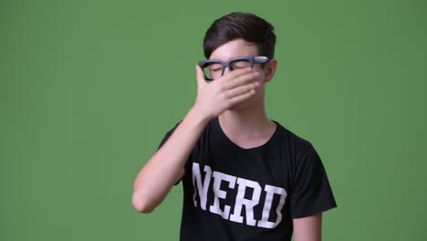 young handsome iranian teenage boy against green background