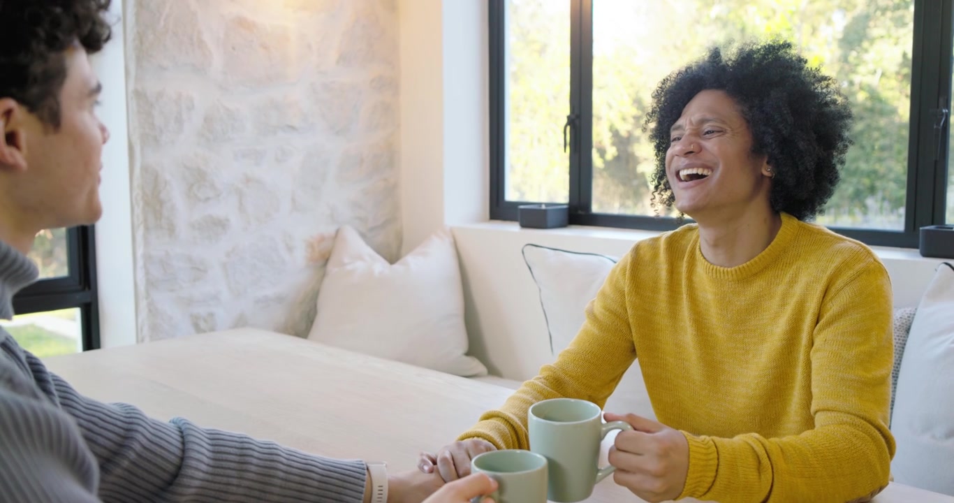 Due amici che conversano e bevono caffè a casa.