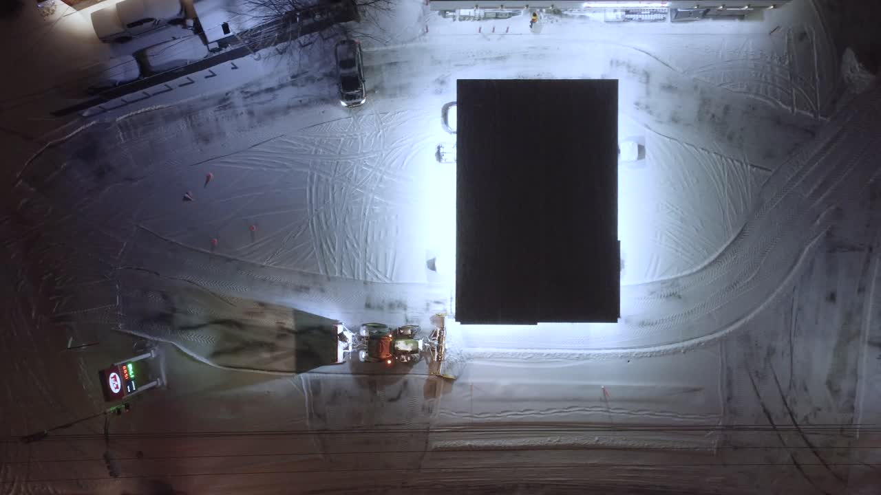 A snowy gas station with bright lighting at night in St-Constant, Québec, Canada