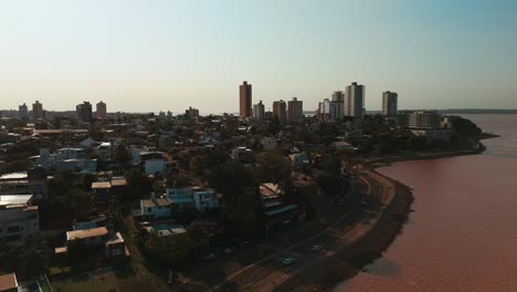 Eine-Seitliche-Luftaufnahme,-Die-Die-Skyline-Von-Posadas-Vor-Dem-Hintergrund-Des-Flusses-Paraná-Zeigt