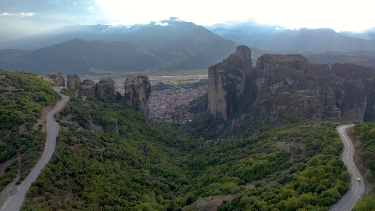 Meteora Rocks and Kalabaka City Aerial Panoramic Shot, Twisty Mountain Road in Foreground, Dolly Shot
