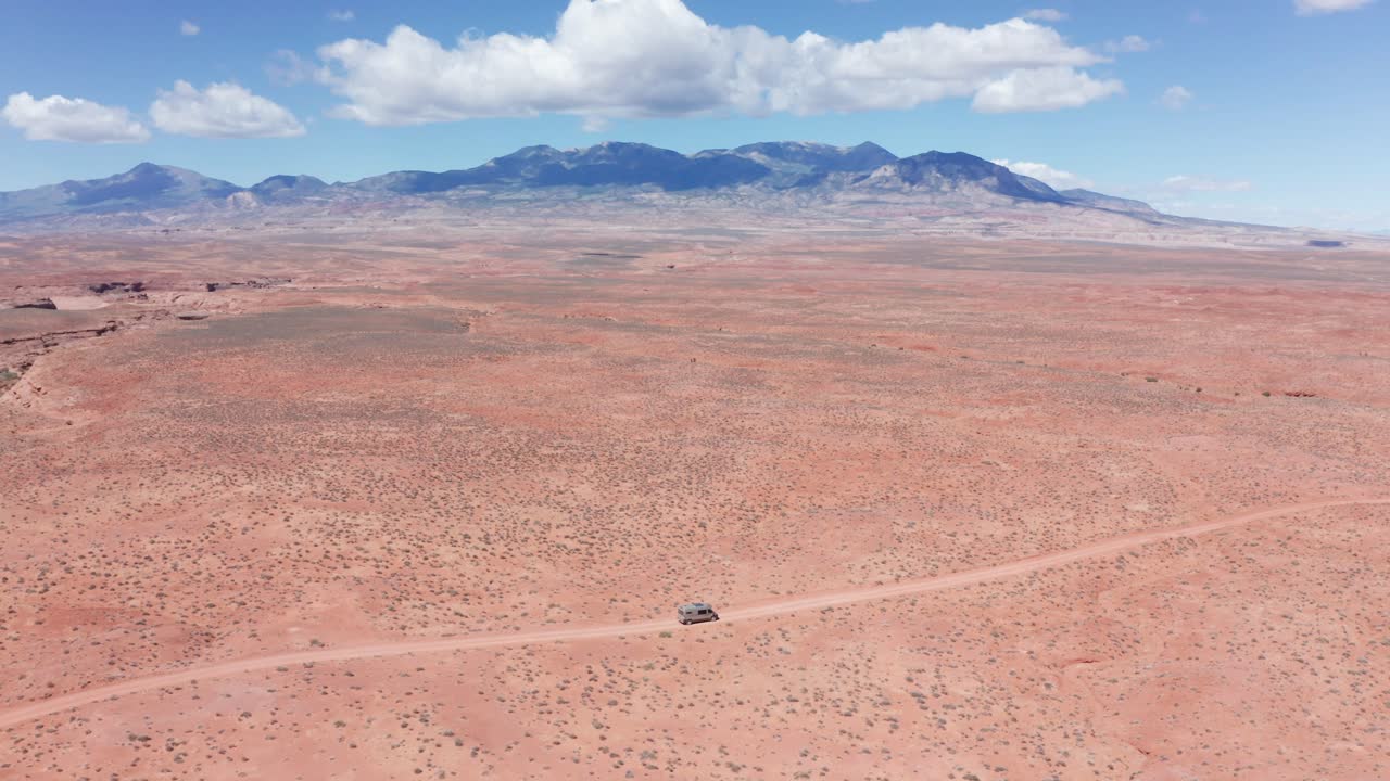 aéreo, camper mini van en un viaje por carretera conduciendo por una carretera del desierto de arenisca en utah