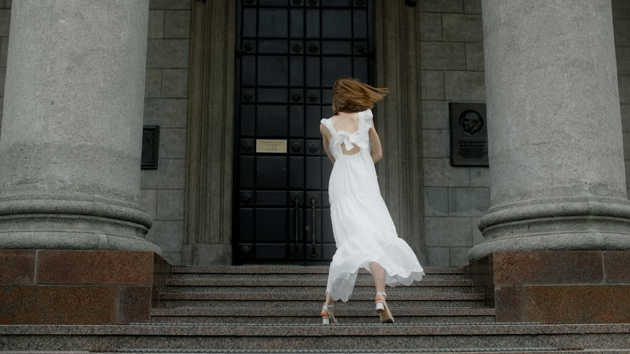 Woman in a white dress dancing on steps