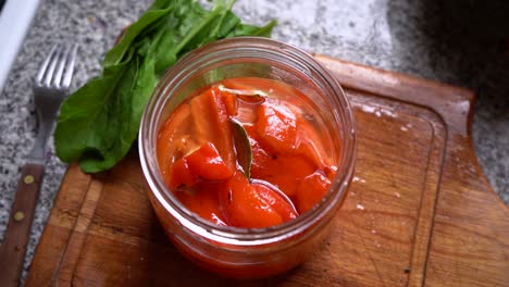 vista superior de pimientos rojos en escabeche en un frasco de vidrio